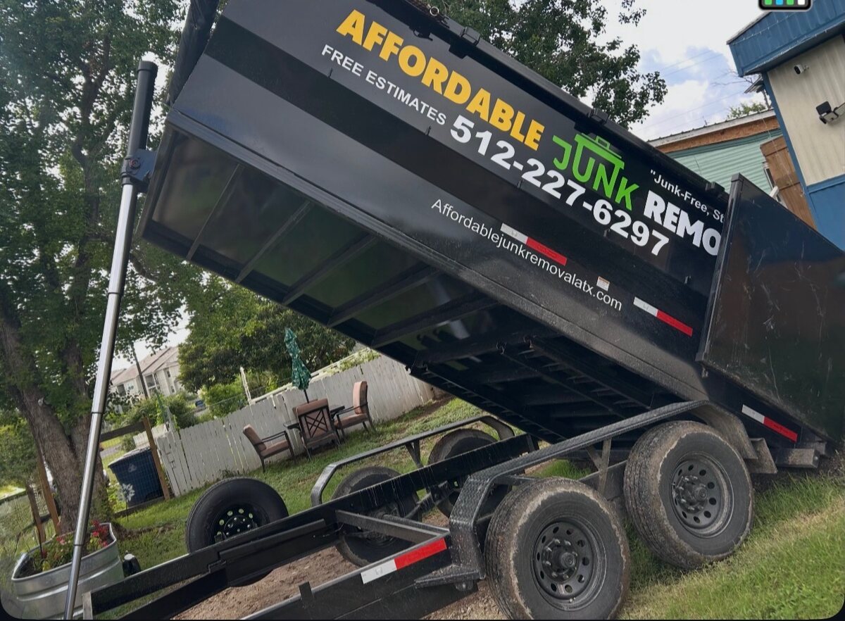 Affordable Junk Removal branded dump trailer tipping a delivery load in Austin, TX